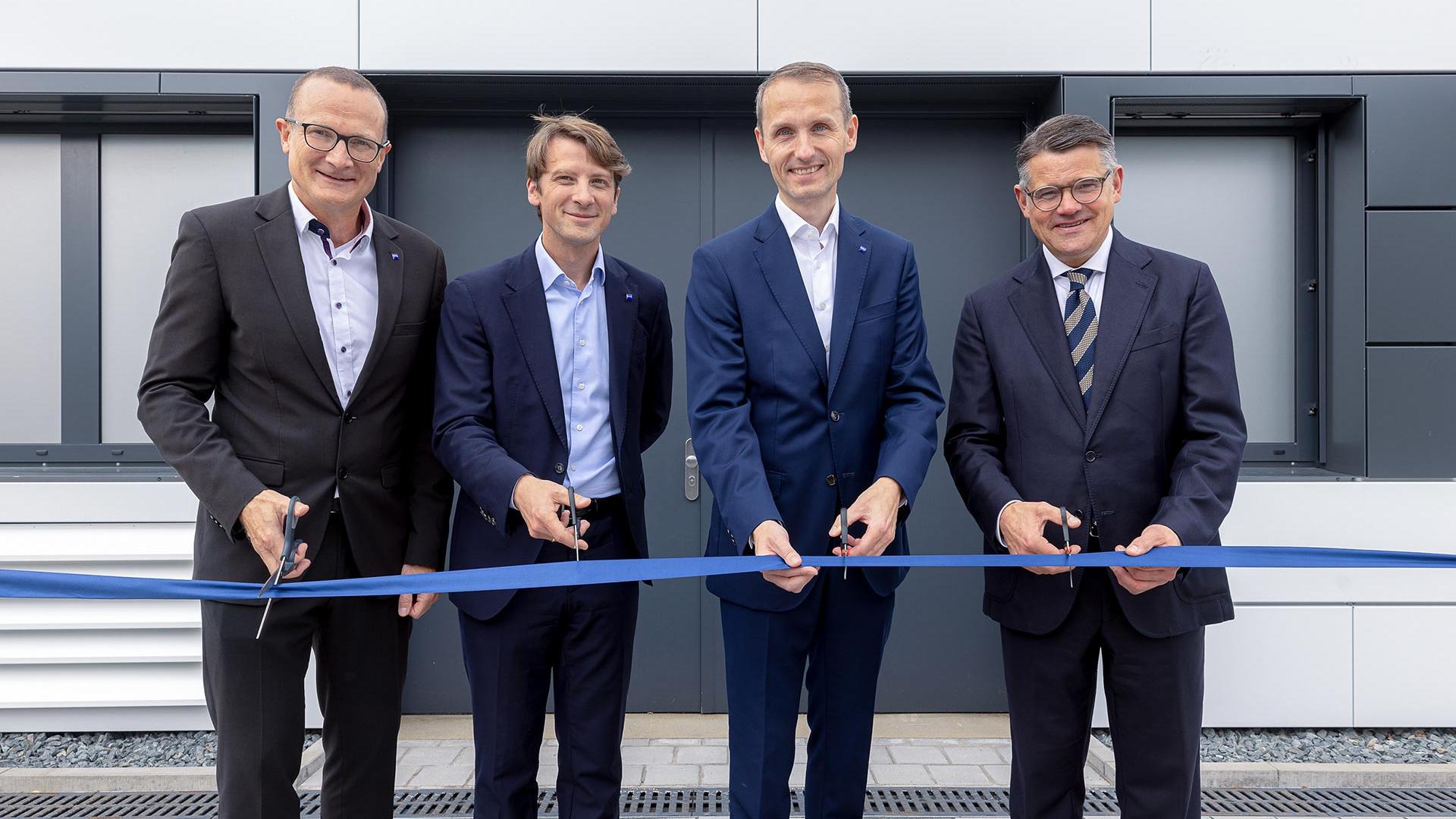 The image shows four people at the ceremonial opening of the new cleanroom space by ZEISS Semiconductor Manufacturing Technology at the Roßdorf site in Hesse. High-precision mask repair systems are developed there.