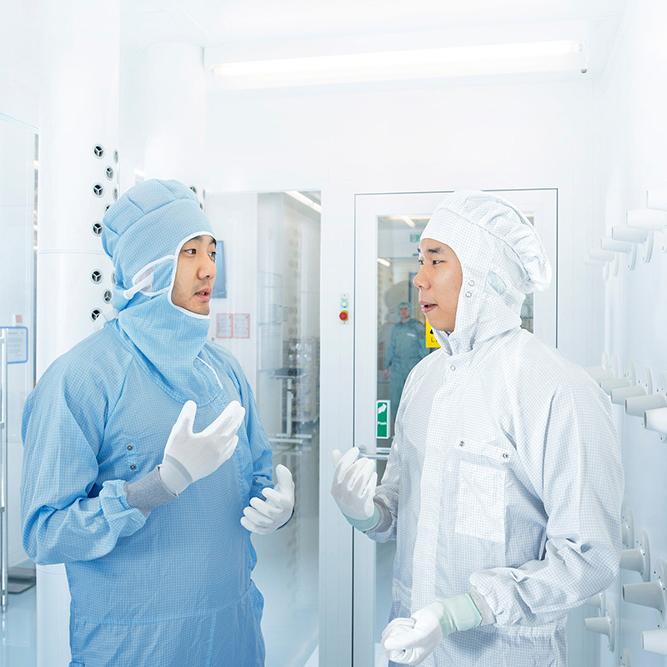 半導體製程控制解決方案部門的兩名員工在蔡司半導體無塵室內對話