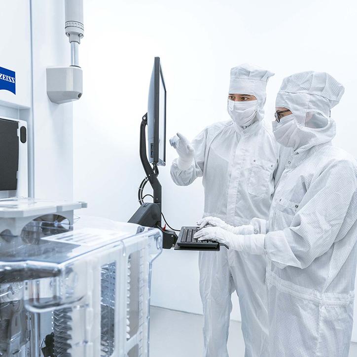 半導體製程控制解決方案部門的兩名員工在蔡司半導體無塵室內對話