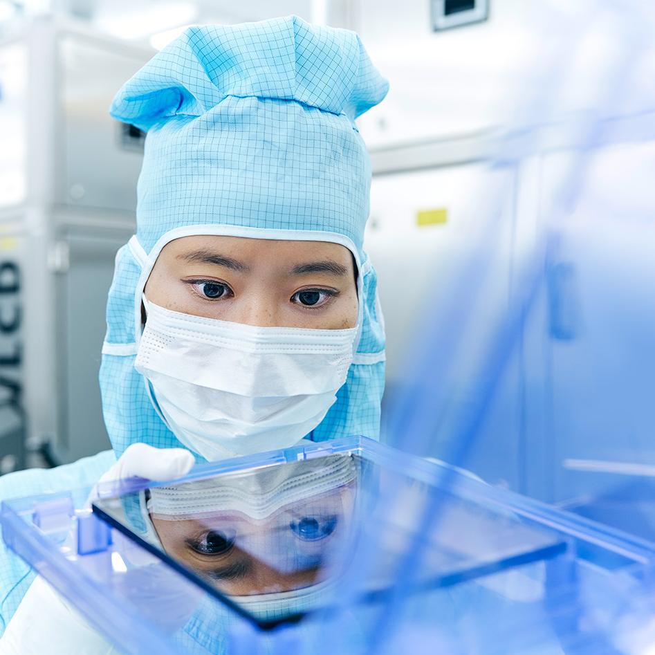 一名員工在無塵室研究光罩解決方案
