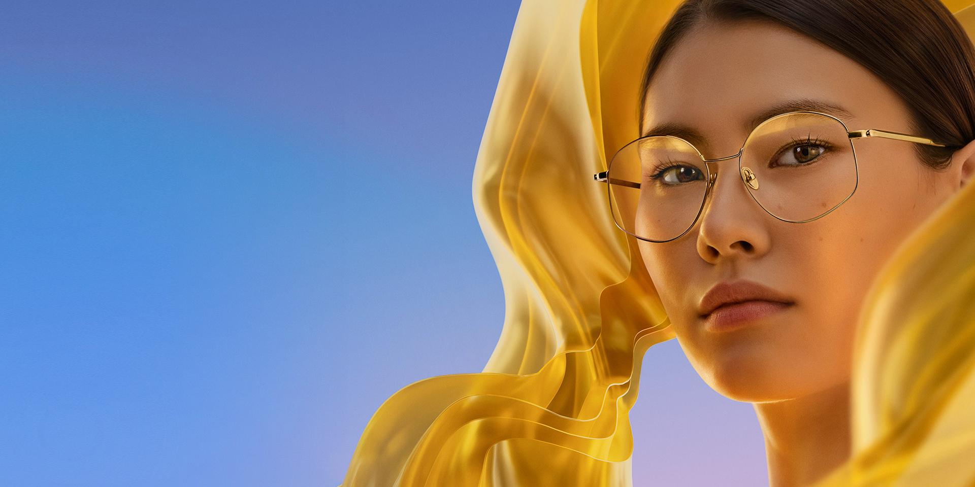 一位女士戴上蔡司 DuraVision Gold UV 透明眼鏡，鏡片上增添了微妙而獨特的金色反射。