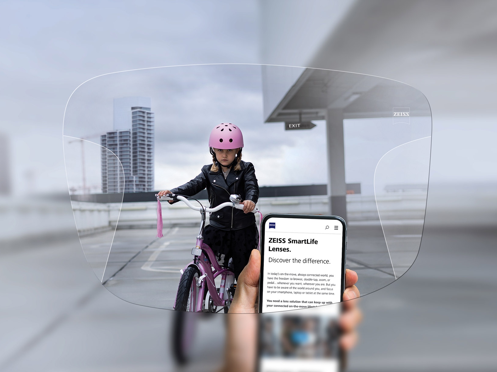 透過蔡司SmartLife智銳漸進鏡片看手機的人。背景可看見一個戴著粉紅色防護頭盔騎單車的女孩。 